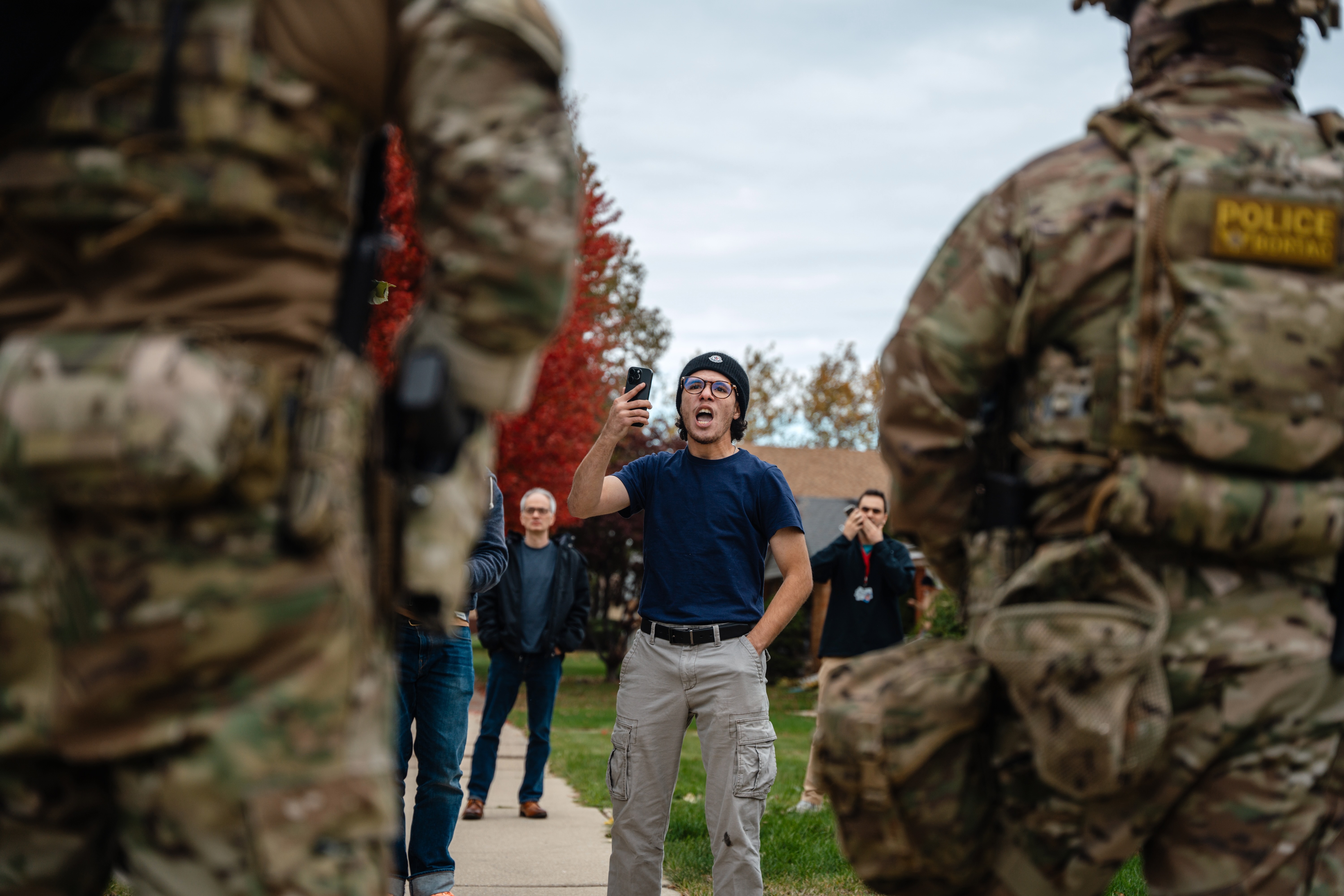 A young man confronts federal agents after they arrested a worker at a home in his Edison Park neighborhood on Friday in Chicago.